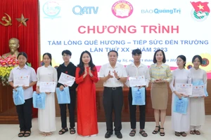 Ông Hà Sỹ Đồng – Phó Chủ tịch thường trực UBND tỉnh Quảng Trị (áo trắng) và bà Dương Thị Hải Yến - Chủ tịch Hội Khuyến học trao học bổng đến tân sinh viên.