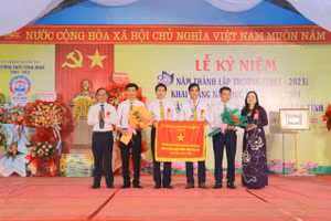 TS Lê Thị Hương, Giám đốc Sở GD&ĐT Quảng Trị trao Cờ thi đua của UBND tỉnh cho Trường THPT Vĩnh Định.