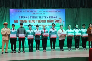 Tặng mũ bảo hiểm cho học sinh.