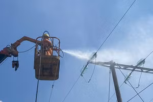 Công nhân Công ty Điện lực Điện Biên thực hiện rửa sứ hotline trên lưới điện.