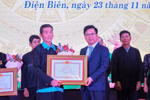 Thừa ủy quyền của Chủ tịch nước, ông Phạm Đức Toàn (bên phải), Phó Chủ tịch Thường trực UBND tỉnh Điện Biên trao tặng danh hiệu cho các Nghệ nhân ưu tú.