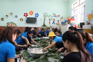 Đại diện Báo GD&TĐ phối hợp cùng giáo viên các Trường mầm non trên địa bàn Tp. Đồng Hới gói bánh chưng tặng bà con nhân dân vùng lũ.