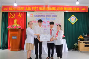 Các em học sinh Trường THPT Phan Huy Chú - Đống Đa (trái) trao tặng sách cho đại diện học sinh Trường THCS Đông La (Hoài Đức, Hà Nội).