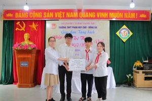 Các em học sinh Trường THPT Phan Huy Chú - Đống Đa (trái) trao tặng sách cho đại diện học sinh Trường THCS Đông La (Hoài Đức, Hà Nội).