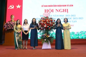 Phó Giám đốc Sở GD&ĐT Hà Nội Trần Lưu Hoa (thứ 3 từ trái sang) tặng hoa chúc mừng thành tích của ngành GD&ĐT quận Nam Từ Liêm.