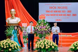 Phó Giám đốc Sở GD&ĐT Nam Định Nguyễn Xuân Hồng (bìa phải) tặng hoa chúc mừng những thành tích của ngành giáo dục huyện Nam Trực trong năm học vừa qua. 