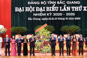 Bí thư T.Ư Đảng, Chánh án Tòa án nhân dân Tối cao Nguyễn Hòa Bình thay mặt Bộ Chính trị, Ban Bí thư T.Ư Đảng tặng hoa chúc mừng Đại hội. (Ảnh: IT).