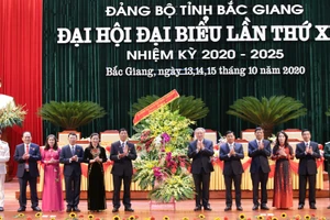 Bí thư T.Ư Đảng, Chánh án Tòa án nhân dân Tối cao Nguyễn Hòa Bình thay mặt Bộ Chính trị, Ban Bí thư T.Ư Đảng tặng hoa chúc mừng Đại hội. (Ảnh: IT).