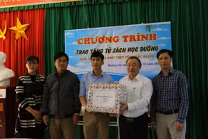 Ông Nguyễn Đắc Hồng – Giám đốc Thư viện tỉnh Bắc Giang (áo trắng) tặng sách cho thư viện Trường Trung học cơ sở xã Hoàng An, huyện Hiệp Hòa.