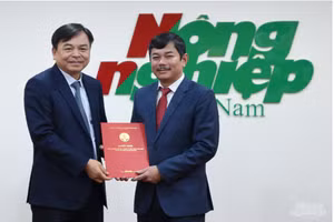 Thứ trưởng Nguyễn Hoàng Hiệp thừa ủy quyền Bộ trưởng Bộ NN-PTNT trao Quyết định bổ nhiệm chức vụ Phó Tổng Biên tập báo Nông nghiệp Việt Nam cho ông Trần Văn Cao (bên phải).