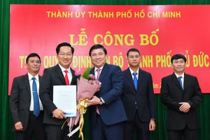 Chủ tịch UBND TPHCM Nguyễn Thành Phong trao quyết định phê chuẩn chức danh chủ tịch UBND TP Thủ Đức cho ông Hoàng Tùng (trái) và 3 Phó Chủ tịch UBND TP Thủ Đức