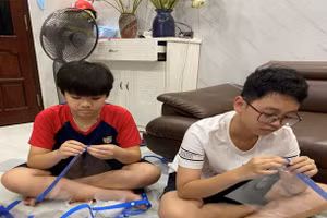 Các em lắp ráp tấm chắn giọt bắn để gửi tặng khu cách ly y tế tập trung