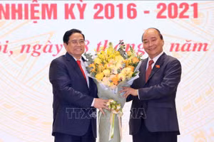 Chủ tịch nước Nguyễn Xuân Phúc, nguyên Thủ tướng Chính phủ tặng hoa chúc mừng Thủ tướng Chính phủ Phạm Minh Chính. Ảnh: TTXVN
