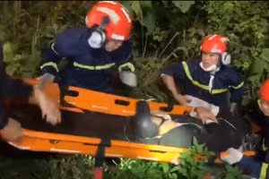 Lực lượng cứu hộ đưa người bị nạn từ vực sâu lên trên đường.