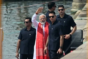 Thủ tướng Ấn Độ Narendra Modi (giữa) vẫy tay sau khi cầu nguyện bên bờ sông Hằng ở Varanasi ngày 14/5. (Ảnh: AFP)