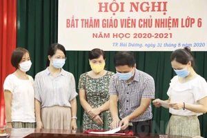 Các giáo viên Trường THCS Lê Quý Đôn thực hiện bốc thăm chủ nhiệm lớp 6. Ảnh: Báo Hải Dương