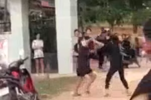 Hai học sinh đánh nhau trước cổng trường (Ảnh cắt từ clip).