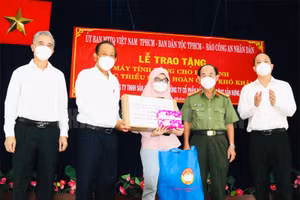 Nguyên Phó Thủ tướng thường trực Chính phủ Trương Hòa Bình cùng đại diện lãnh đạo TP Hồ Chí Minh trao tặng máy tính xách tay cho em Asikine Hồng, học sinh lớp 12 Trường THPT Tạ Quang Bửu (Ảnh: Thành ủy TP).