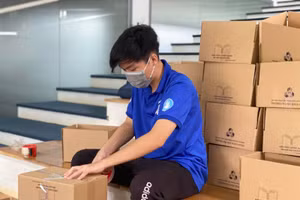 Cán bộ, nhân viên của trường đóng gói những bộ sách giáo trình gửi cho sinh viên. Ảnh: Thy Huyền