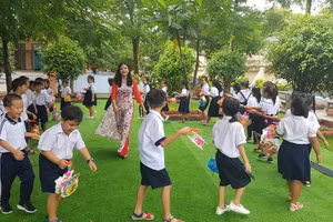 Cô Lê Thị Kim Thúy - Hiệu trưởng Trường TH Phú Hòa 3 cùng học trò vui chơi trong công viên xanh đầy ắp tiếng cười hạnh phúc (Ảnh: NTCC)