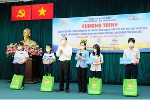 Phó Bí thư Thành ủy TP.HCM Nguyễn Hồ Hải và Chủ tịch Hội Nông dân TP Hồ Chí Minh Nguyễn Thanh Xuân trao học bổng và thiết bị học trực tuyến cho học sinh.