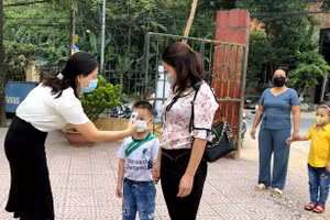 Kiểm tra thân nhiệt học sinh trước khi bước vào trường.