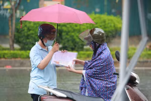 Phụ huynh cùng thí sinh đội mưa đến điểm thi.