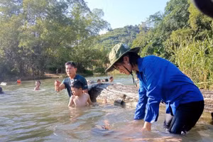 Đoàn viên hỗ trợ các em tập lặn dưới suối.