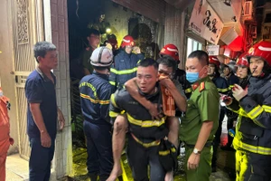 Thượng úy Nguyễn Viết Quân cõng ông Đỗ Đức Kiện đang dần ngất lịm thoát khỏi đám cháy.