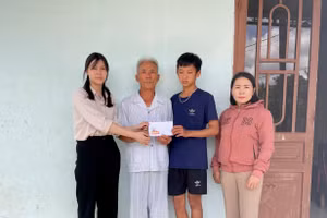 Đại diện Báo GD&TĐ trao tiền hỗ trợ của bạn đọc cho gia đình 3 cháu bé mồ côi ở Gia Lai.