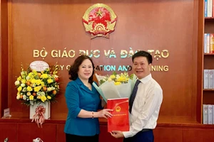 Thứ trường Ngô Thị Minh trao Quyết định bổ nhiệm và tặng hoa chúc mừng Tân Phó Vụ trưởng Vụ Giáo dục Thể chất Nguyễn Nho Huy. Ảnh: An Nhiên