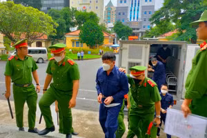 Các bị cáo trong vụ án 13 cán bộ công an phường nhận chung chi để thả người bị dẫn giải đến phiên xét xử sơ thẩm sáng 28/8. Nguồn: A.T