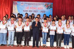 Thầy Nguyễn Đức Hồng (áo đen, đứng giữa) trao phần thưởng cho các em đạt học sinh giỏi các cấp.