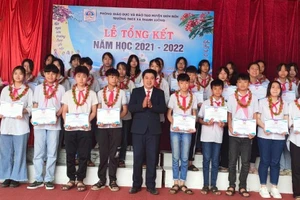 Thầy Nguyễn Đức Hồng (áo đen, đứng giữa) trao phần thưởng cho các em đạt học sinh giỏi các cấp.