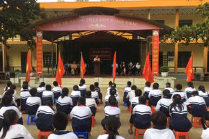 Học sinh toàn trường chăm chú nghe phổ biến Luật Giao thông đường bộ.