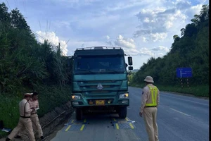 Lực lượng CSGT tiến hành giám sát việc cân tải trọng xe trên Quốc lộ 6