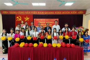 Lãnh đạo huyện Nậm Pồ cùng học sinh tại điểm cầu chính của Lễ phát động tiết kiệm.