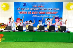 Niềm vui của các em HS khi được trao tặng bộ máy tính để học trực tuyến.