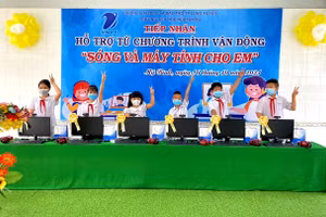 Niềm vui của các em HS khi được trao tặng bộ máy tính để học trực tuyến.