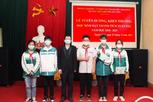 Thầy Trần Minh Tú và học sinh đạt thành tích môn Vật lý.