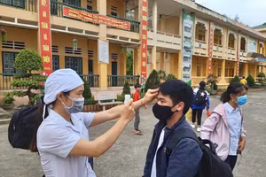 Học sinh trở lại trường được kiểm tra thân nhiệt đầy đủ.