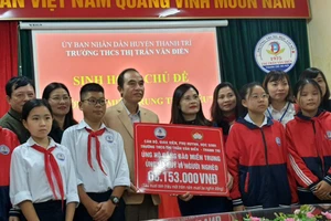 Ông Nguyễn Huy Chương, Chủ tịch UBMTTQ Việt Nam huyện Thanh Trì đại diện tiếp nhận phần quà của thầy trò Trường THCS Thị trấn Văn Điển trao tặng.