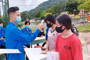 Đo thân nhiệt cho thí sinh đến đăng ký dự thi tốt nghiệp THPT năm 2021. Ảnh: Tuấn Ngọc