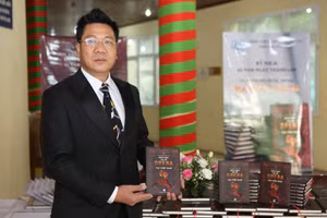 TS. NSND Đỗ Quốc Hưng bên cuốn sách vừa được ra mắt.