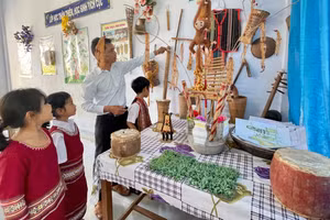 Thầy A Dưnh dạy học sinh tiếng Jrai thông qua đồ dùng, nhạc cụ truyền thống của dân tộc. Ảnh: Trúc Hân