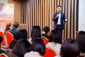 Anh Nguyễn Việt Hoàng trong buổi họp hướng dẫn đoàn làm thủ tục xuất cảnh.