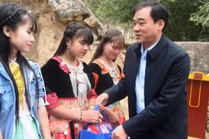 Ông Hoàng Văn Dũng - Phó Chủ tịch Thường trực UBND huyện Mường Lát (Thanh Hóa) trao quà Tết của nhà từ thiện cho học sinh xã Mường Lý.