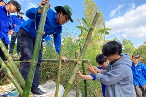 Thầy Võ Ngọc Bia (đội nón tai bèo) cùng đoàn viên thực hiện công trình chống sạt lở “Bờ tre xanh”.