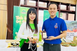 Nguyễn Cao Trần Phương - sinh viên Trường Đại học Vinh (bên phải) và sản phẩm khởi nghiệp “Rượu EM - rượu hoa quả ít độ, nồng độ thấp”. Ảnh: NVCC