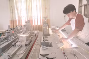 Trịnh Tuấn Kiệt bên bộ sưu tập mô hình tàu quân sự.